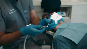 Dental professional performing a dental procedure with dental tools and patient in chair at Hewett’s Dental in Brighouse, Huddersfield, Halifax, Bradford.